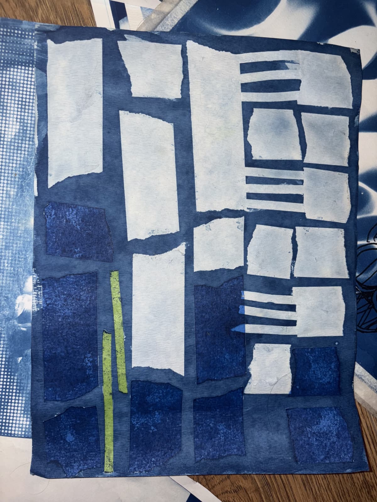Geometric cyanotype composition featuring a grid of white and light blue rectangular shapes against a deep blue background, with a distinctive vertical green stripe on the left side.
